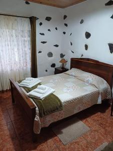 1 dormitorio con 1 cama con toallas en Casa da Queijaria en Faja Grande