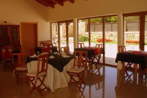 a dining room with tables and chairs and windows at Otium Country House in Alvorge