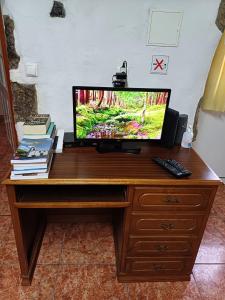 a television sitting on a wooden desk at Casa da Queijaria in Faja Grande