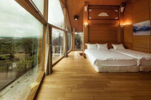 sypialnia z łóżkiem i dużym oknem w obiekcie Pine Tree Resort  w mieście Zhushan