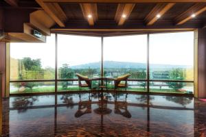jadalnia ze stołem i krzesłami oraz dużymi oknami w obiekcie Pine Tree Resort  w mieście Zhushan