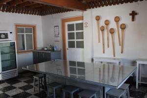 a kitchen with a glass table and wooden spoons on the wall at Hotel El Rincón de Jesusita in Durango