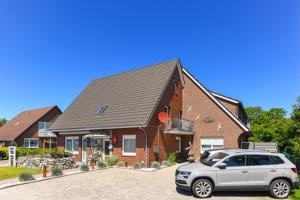 ein Haus mit einem davor geparkt in der Unterkunft Ferienwohnungen Haus Boje in Neuharlingersiel