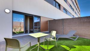 un patio con mesa y sillas en un edificio en Livensa Living Studios Madrid Alcobendas, en Alcobendas