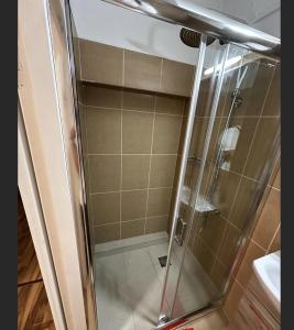 una doccia con porta in vetro in bagno di Modern Cozy Central Flat a Patra