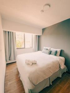 1 dormitorio con 1 cama blanca grande y ventana en Entire Beautiful condo with rooftop pool and gym, en Colonia San Benito