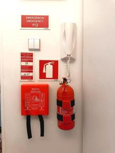 a fire extinguisher and a fire hydrant on a wall at CerezinoFlats-Estúdio Vista Baía in Seixal