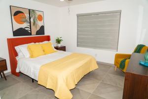 a bedroom with a bed with a yellow blanket and a window at Mid-Century Modern Retreat in Mission