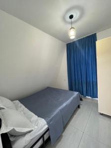 1 dormitorio con cama y cortina azul en Royalhouse - A-Frame Villa Qəbələ en Gabala