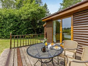 a table and chairs on the deck of a cabin at 1 Bed in South Molton OAKVI in South Molton