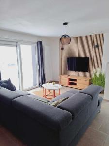 sala de estar con sofá y TV en Lu Bê mont, en Stavelot