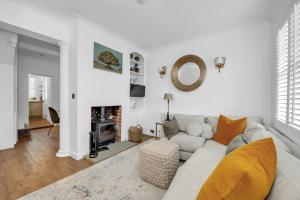 a white living room with a couch and a fireplace at Charming Church Walk - 2 bedroom property with parking in Long Melford