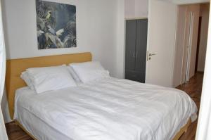a white bed in a room with a painting on the wall at Modern Cozy Central Flat in Patra