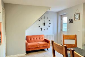 a living room with a chair and a clock on the wall at Spacious Modern House with Great Transport Links and Long Stay Discounts in Thurcaston