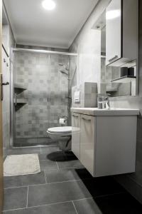 a bathroom with a sink and a toilet and a shower at Cherry Berry Apartmani in Eminovci