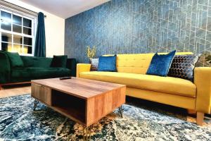 a living room with a yellow couch and a coffee table at Spacious Modern House with Great Transport Links and Long Stay Discounts in Thurcaston