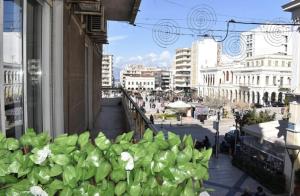 a building with a bunch of green flowers on a street at Modern Cozy Central Flat in Patra
