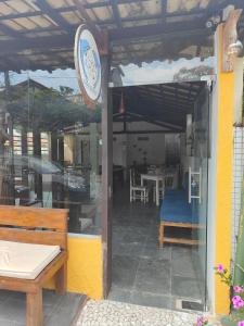 a store front with a bench and a table and chairs at Pousada Bellas Artes in Mata de Sao Joao