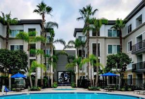an apartment building with a pool and palm trees at HubLife Your Private Oasis in the Heart of Marina del Rey in Los Angeles