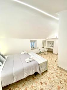 a white bedroom with a large bed and a desk at A&A B&B Martina Franca in Martina Franca