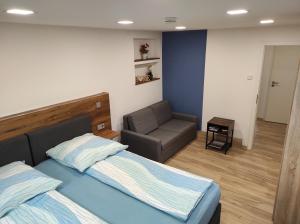 ein Schlafzimmer mit einem Bett und einer Couch in der Unterkunft TinyFeWo Markdorf in Markdorf