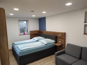 ein kleines Schlafzimmer mit einem Bett und einer Couch in der Unterkunft TinyFeWo Markdorf in Markdorf