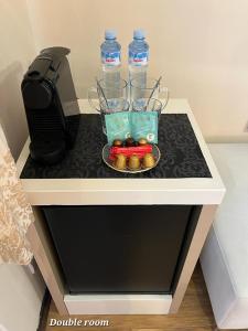 - une table avec deux bouteilles d'eau et un plateau de bonbons dans l'établissement Metropolitan Rooms, à Belgrade