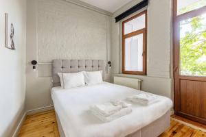 - une chambre avec un grand lit blanc et des serviettes dans l'établissement Pin Exclusive 1 BD Taksim B3, à Istanbul