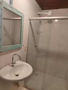 a bathroom with a sink and a shower with a mirror at Pousada Bellas Artes in Mata de Sao Joao