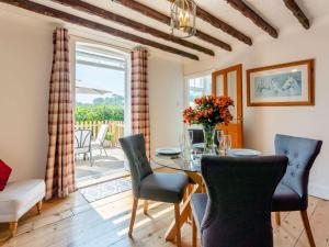 una sala da pranzo con tavolo, sedie e finestra di 2 bed property in Ventnor 82973 a Wroxall