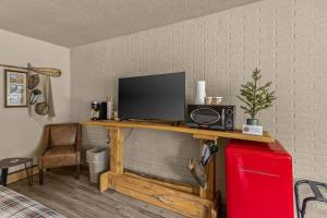 een televisie op een houten tafel in een woonkamer bij Stonegate Lodge Fire Pit 50in TV Salt Water Pool Fast Wi-Fi Room #301 in Eureka Springs