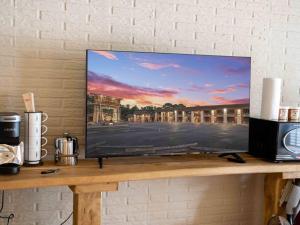 a flat screen tv sitting on top of a shelf at Stonegate Lodge Fire Pit 50in TV Salt Water Pool Fast Wi-Fi Room #301 in Eureka Springs