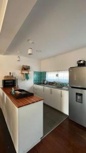 une grande cuisine avec des placards blancs et un comptoir dans l'établissement Casa en La Paloma cerca de la playa, à La Paloma