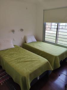 une chambre avec deux lits et une fenêtre dans l'établissement Casa en La Paloma cerca de la playa, à La Paloma