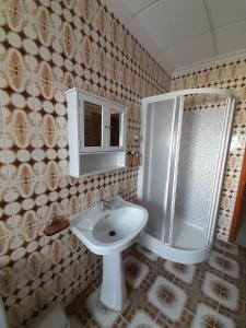 ein Badezimmer mit einem weißen Waschbecken und einer Dusche in der Unterkunft CASA DE PUEBLO Fuente Buena in Arroyo del Ojanco