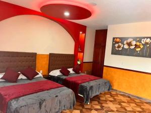 - une chambre avec deux lits et un plafond rouge dans l'établissement Hotel La Cueva del Pirata, à Casitas