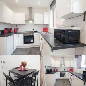 a kitchen with white cabinets and a table with a microwave at Lovely 2 Bedroom House Sheffield Central Location in Sheffield