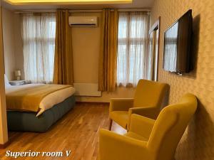 une chambre d'hôtel avec un lit et deux chaises dans l'établissement Metropolitan Rooms, à Belgrade
