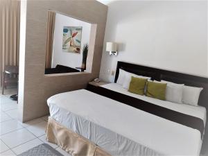 ein Schlafzimmer mit einem großen Bett in einem Hotelzimmer in der Unterkunft HOTEL VILLA LAS ROSAS TEPIC in Tepic