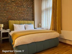 a bedroom with a bed with a brick wall at Metropolitan Rooms in Belgrade