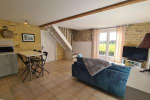 ein Wohnzimmer mit einem blauen Sofa und einem Tisch in der Unterkunft Les gîtes du Kokopelli : Maupiti in Plumelec