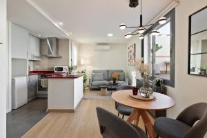 cocina y sala de estar con mesa y sillas en Apartments Barcelona & Home Deco Eixample, en Barcelona