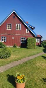 a red barn with a flower pot in front of it at Appartment in Nida in Nida