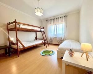 a bedroom with two bunk beds and a desk at La villa du Paradis du Coto - Piscine-Mer&Surf in Coto