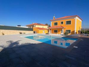 a large swimming pool in front of a house at La villa du Paradis du Coto - Piscine-Mer&Surf in Coto