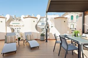 patio con mesa y sillas en el balcón en Apartments Barcelona & Home Deco Eixample, en Barcelona