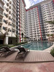 a swimming pool with two chairs and two buildings at Family Home in Manila