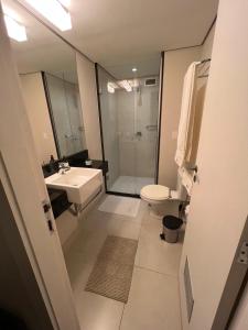 W łazience znajduje się umywalka, toaleta i prysznic. w obiekcie Flat com Vista Deslumbrante na Praia do Pecado w mieście Macaé