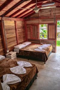 2 Betten in einem Zimmer mit Holzwänden in der Unterkunft Hotel Campestre La Francesina in Betania
