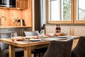 a table with food and wine bottles on it at Höra‘s Apartments Hammerbergblick in Münchberg